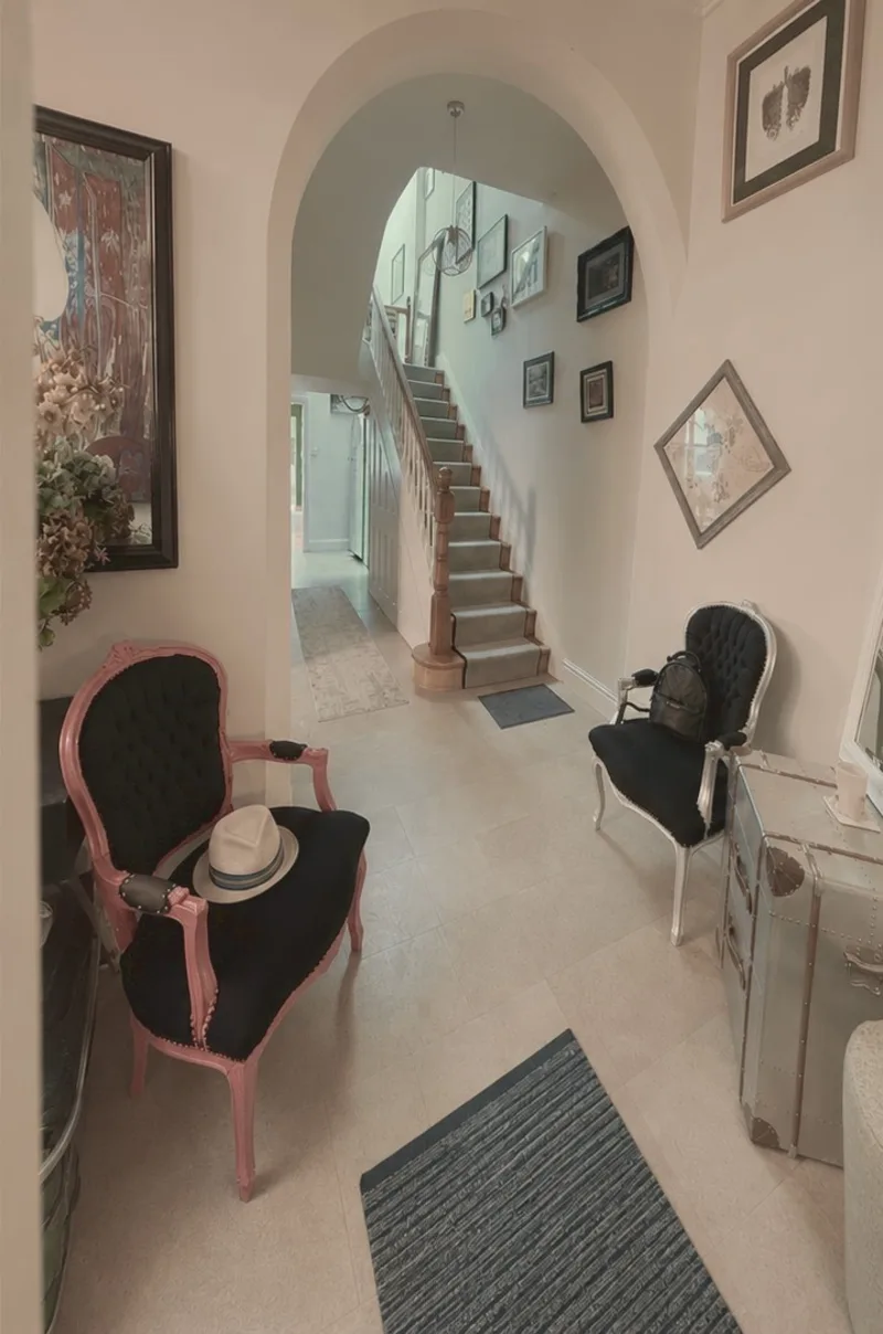 The same hallway cleared, with a pink armchair standing on its own